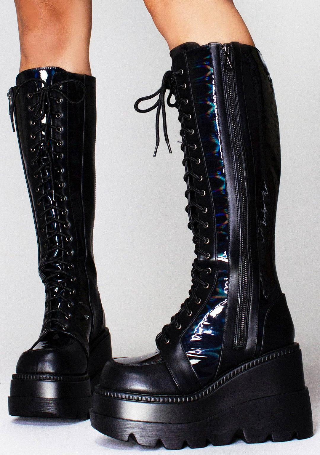 Black knee-high boots with platform sole on a light gray background