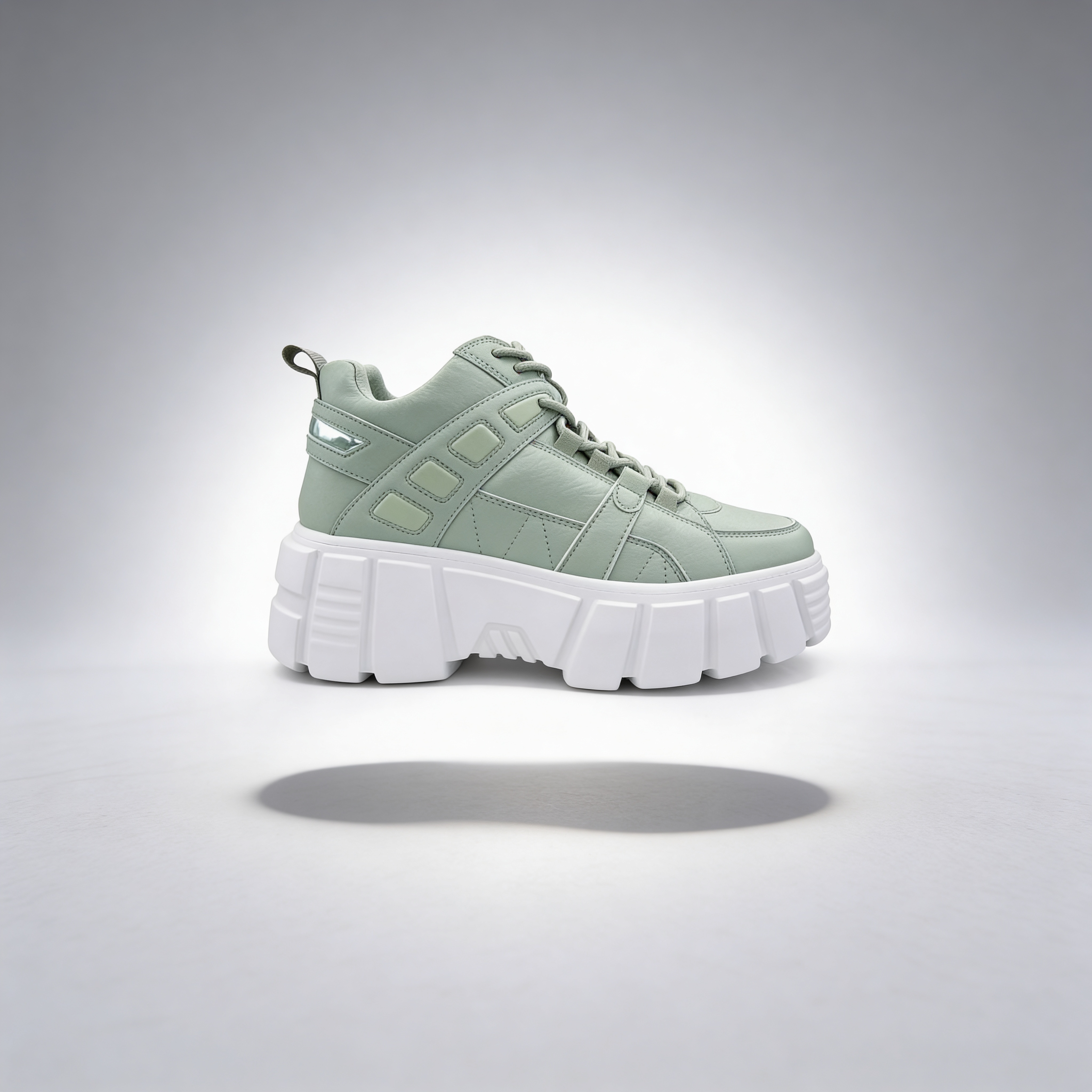Light green sneaker with white sole on a gray background