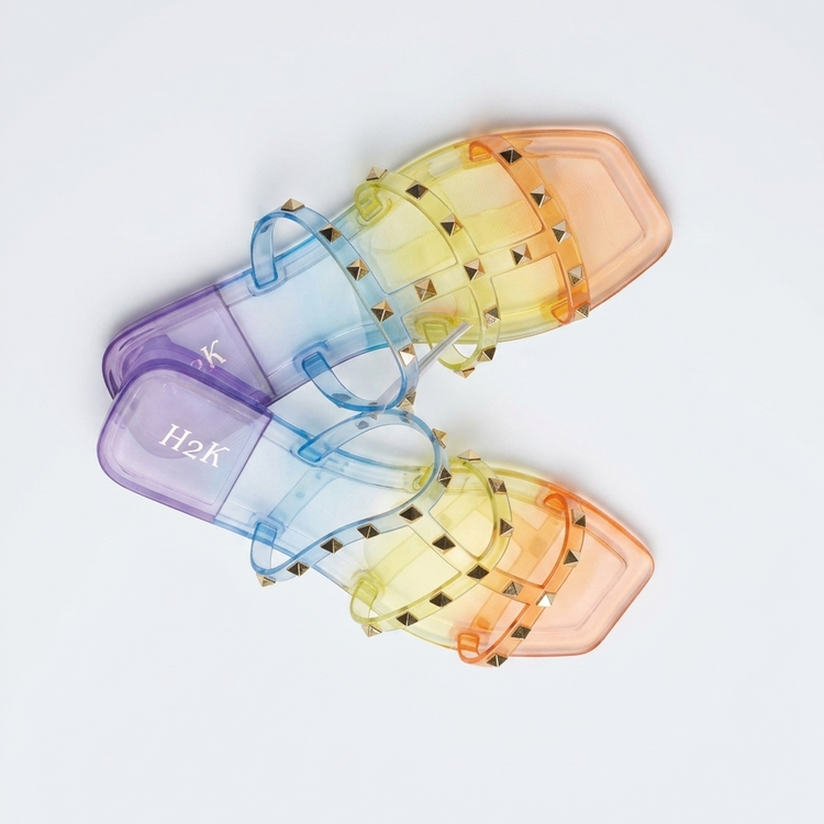 Set of colorful transparent sunglasses with 'H2K' branding on a light gray background