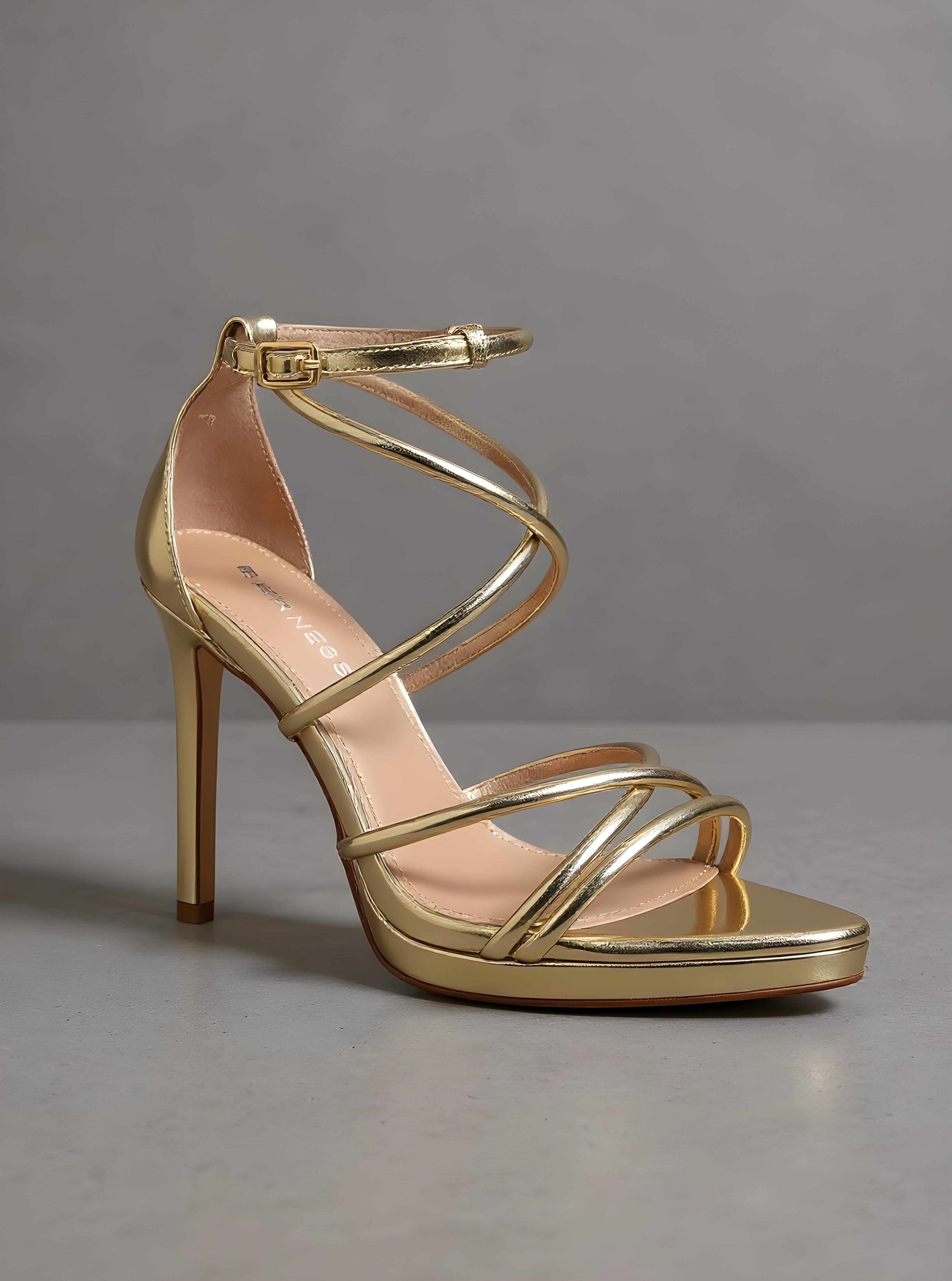 Gold high-heeled sandal on a gray background