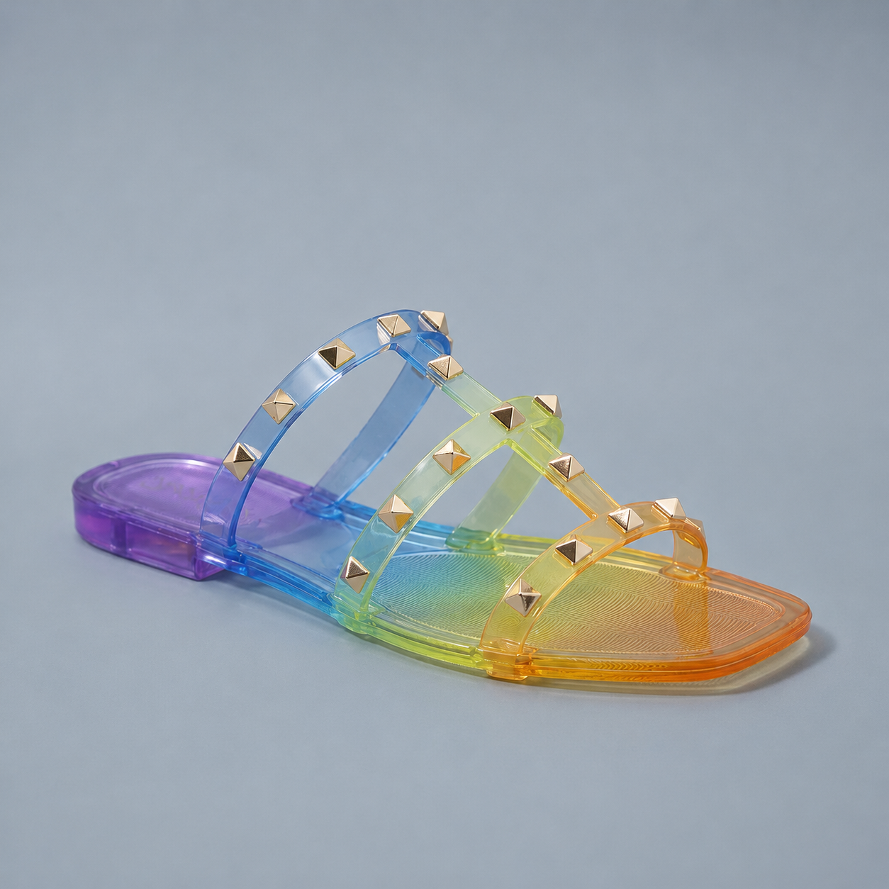 Multicolored jelly sandal with gold studs on a gray background