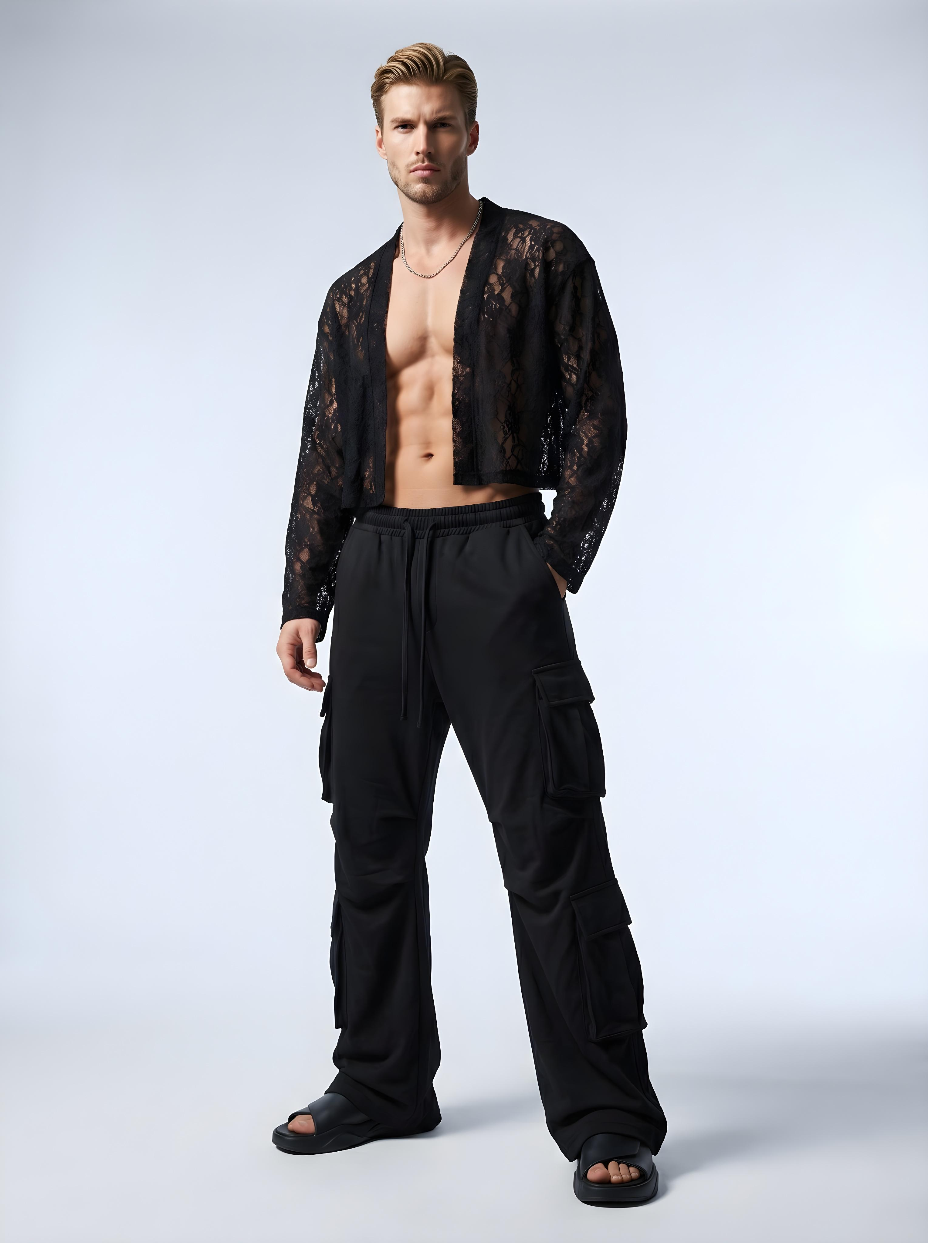 Man wearing a black lace top and black pants on a white background
