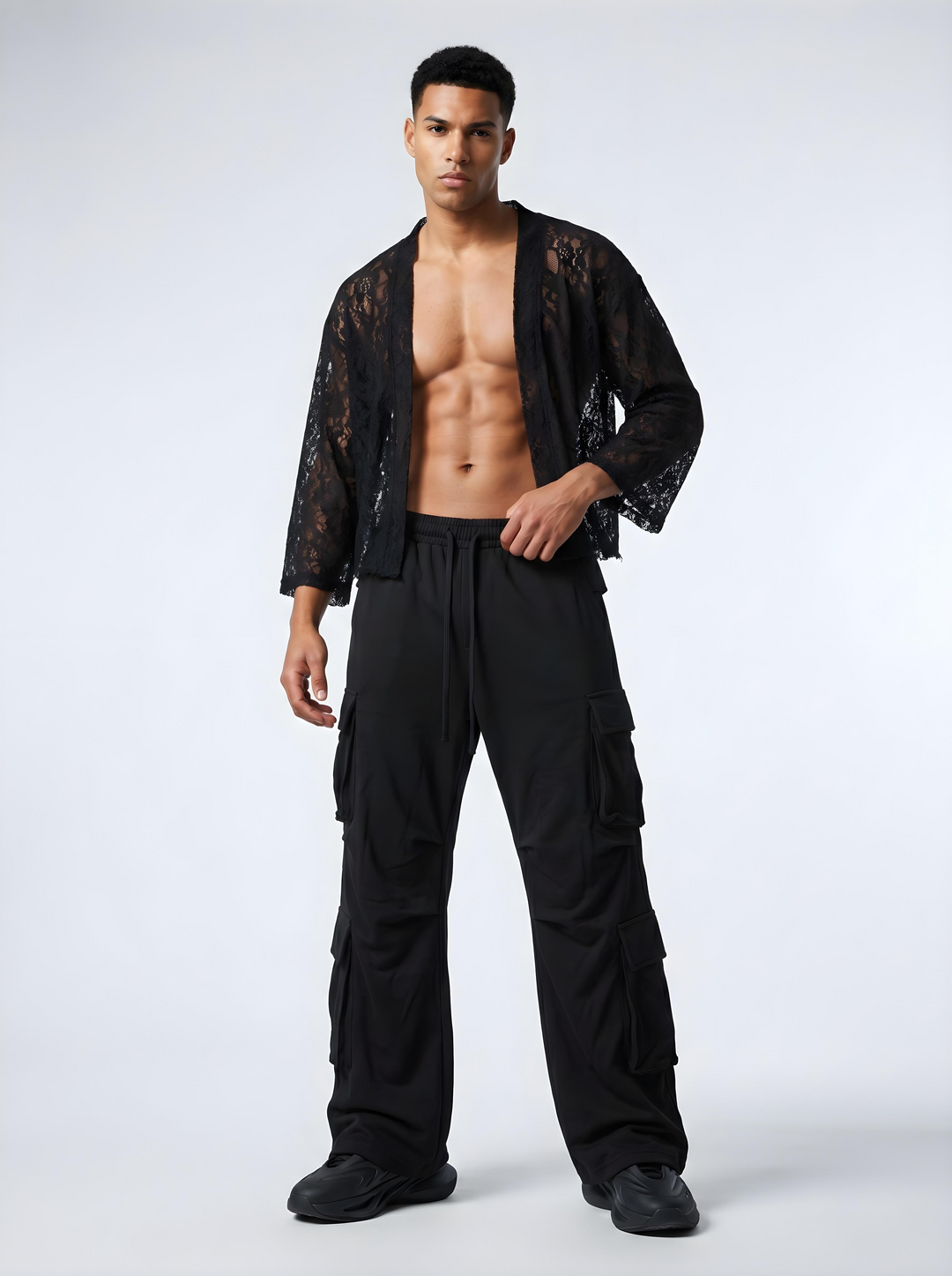 Man wearing a black lace shirt and cargo pants on a white background