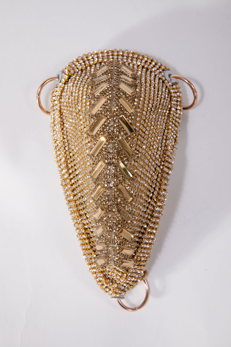 This image features the "CODPIECE - AGED GOLD," an exquisite piece of wearable art. It showcases an intricate, teardrop-shaped design, meticulously adorned with hand-appliquéd gemstones in varying shades of gold.